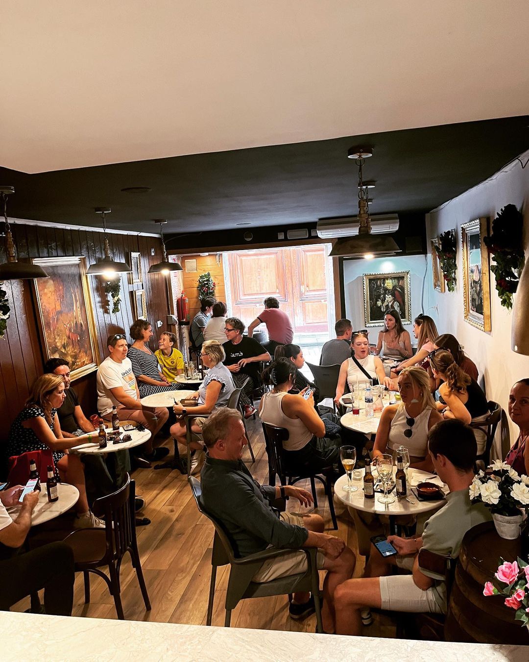 The busy dining room at Casa Vani, with marble-topped tables, bentwood chairs and brass pendant lamps